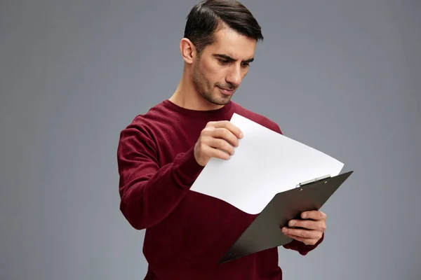 Knappe man in een rode trui map voor papieren poseren business en office concept — Stockfoto