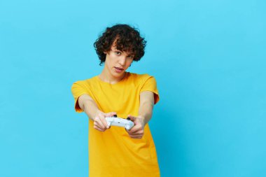 Adam sarı tişörtlü joystickle oynuyor. Hayat tarzı eğlence.