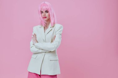 Güzel, genç, çekici bir kadın. Beyaz ceketli, pembe peruklu, arka planda değişiklik yok.