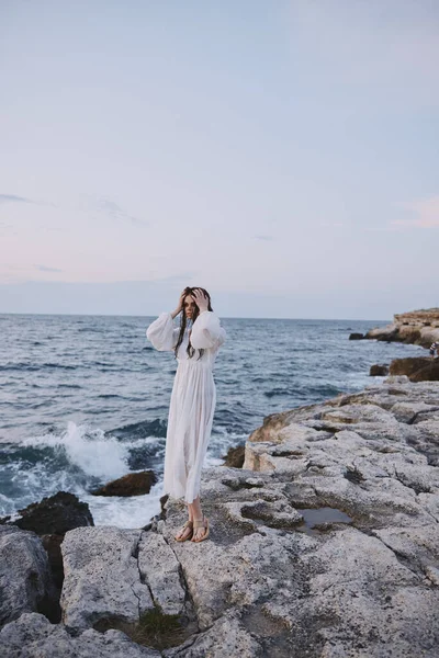 Okyanus taşlarının yanında güzel bir kadın yürüyor. — Stok fotoğraf