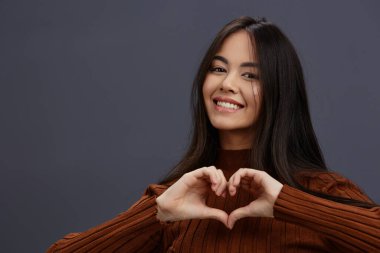 Güzel kadın kahverengi süveter cazibeli gülümseme moda gri arka plan