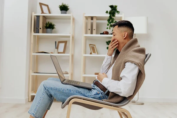 Asiatico uomo casa con computer portatile in sedia interno internet stile di vita lavoro — Foto Stock