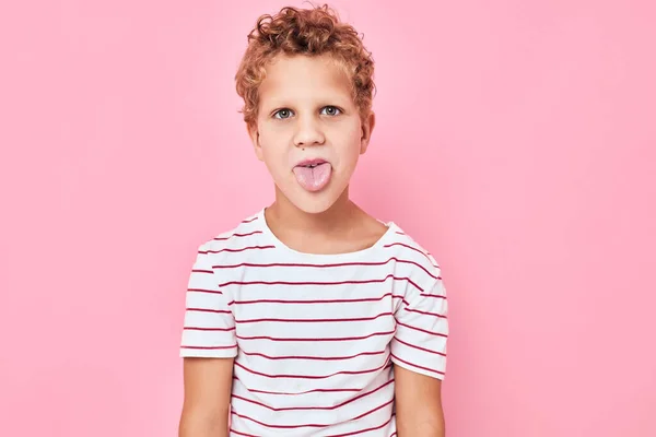 Słodkie chłopiec w paski t-shirt różowy kolor tło — Zdjęcie stockowe
