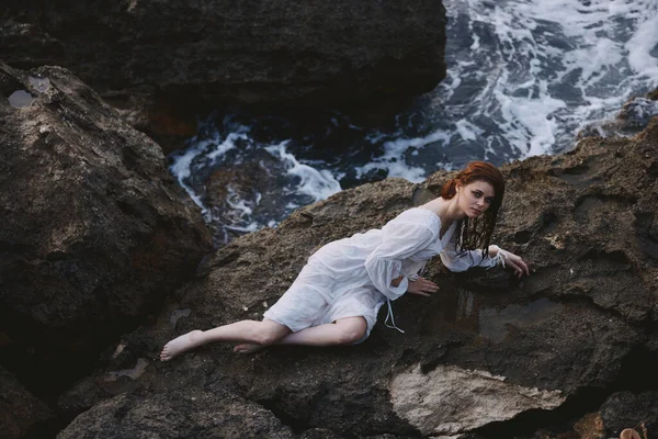 赤脚女人躺在岩石海岸上，毫发无损 — 图库照片