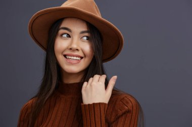 Şapkalı, kahverengi süveterli güzel bir kadın. Günlük kıyafet stüdyo modeli.