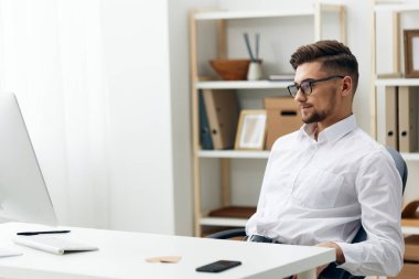 Beyaz gömlekli işadamları bilgisayar ofisinde oturuyor.