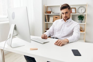 Ofiste çalışan beyaz gömlekli yakışıklı adam internet yöneticisi.