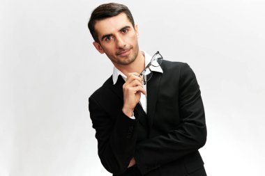 Siyah takım elbiseli, özgüvenli bir iş adamı elinde bir bankanın arka planında çalışıyor. beyaz stüdyo arkaplanı, kopyalama alanı