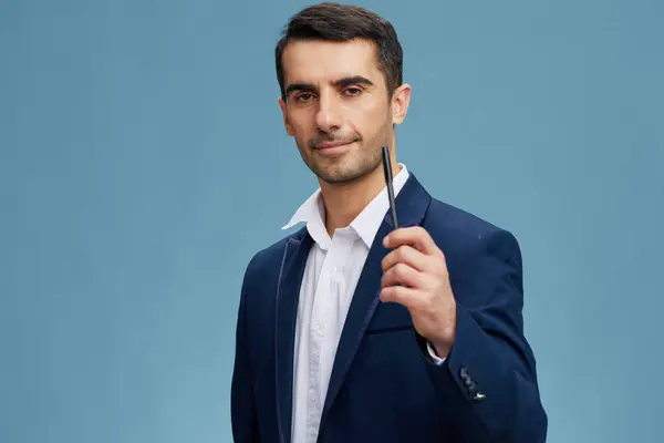 Homens de negócios caneta na mão em um terno elegante posando auto-confiança fundo azul — Fotografia de Stock
