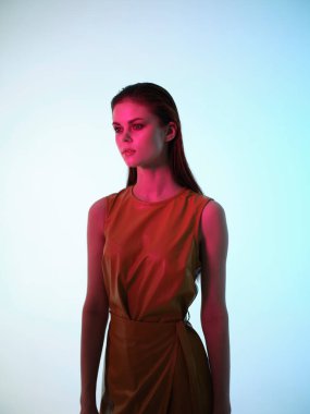 Lüks model pozu veren deri elbiseli çekici bir kadın.