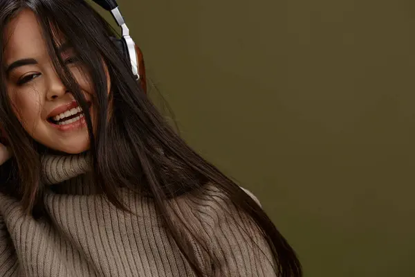 portrait woman in a sweater listening to music with headphones fun Lifestyle