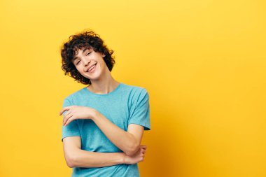 Sarı arka plan modasına uygun kıvırcık saçlı yakışıklı adam.