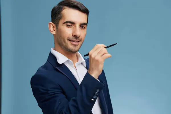 Gerente segurando uma caneta na frente dele posando auto-confiança fundo azul — Fotografia de Stock