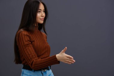 Kadın kahverengi süveter cazibeli gülümseme moda gri arka plan