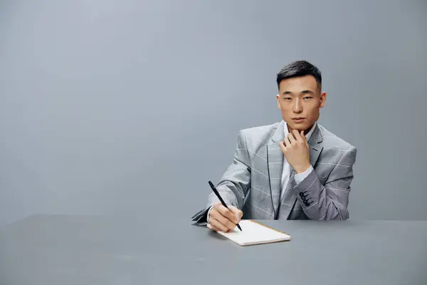 man in a gray suit in the office with a notepad on the table the idea of writing Lifestyle