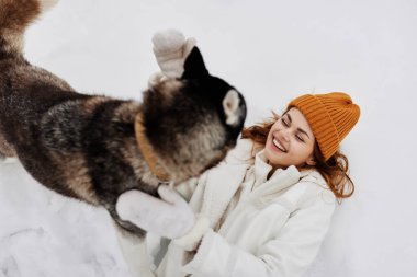 Genç kadın kış kıyafetleri kış tatilinde köpeği gezdirir. Yüksek kalite fotoğraf