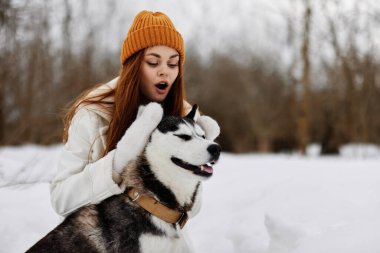 Genç bir kadın kışın bir tarlada köpek yaşam tarzıyla yürüyor. Yüksek kalite fotoğraf