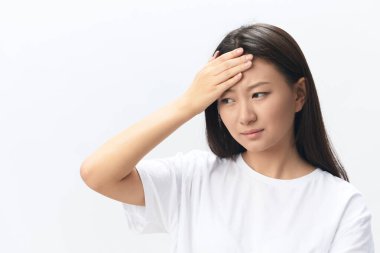 Migrenim tuttu. Beyaz arka planda soyutlanmış pozlar veren bronzlaşmış, bronz tenli, genç bir Asyalı kadının alnına dokunuşunun yan görüntüsü. Yaralar Kötü Sağlık Hastalığı konsepti. Güzel teklif Banner.