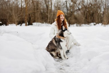 Safkan köpeği olan bir kadın dışarıda oyun oynuyor kar eğlencesi kış tatillerinde seyahat ediyor. Yüksek kalite fotoğraf