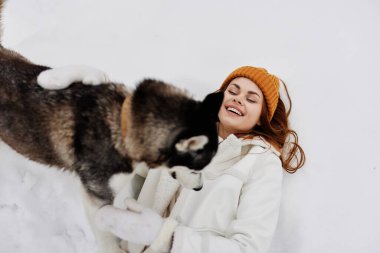 Bir kadın kışın köpek kış tatiliyle birlikte bir tarlada yürüyüş yapıyor. Yüksek kalite fotoğraf