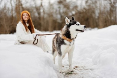 Genç kadın kış kıyafetleri karda köpeği gezdiriyor. Yaşam tarzı. Yüksek kalite fotoğraf