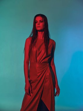 Lüks model pozu veren deri elbiseli genç bir kadın. Yüksek kalite fotoğraf