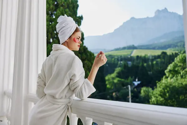 Sensual and beautiful woman in a robe stands on an open balcony Perfect sunny morning. High quality photo