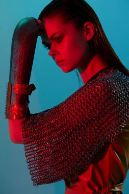 Glamor adlı genç bir kadın arka planda kırmızı ışıklı metal zırh kullanıyor. Yüksek kalite fotoğraf