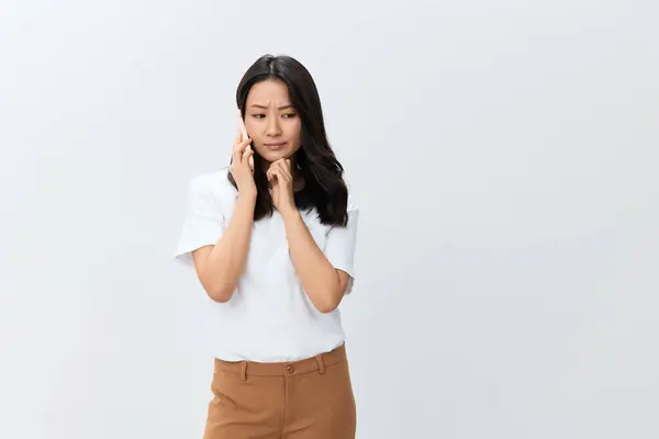 身穿白色基本T恤的聪明可爱的亚洲年轻女性从导演那里得到了重要的信息 她们使用的是在白色背景下隔离的手机姿势 最好的广告报价 人的生活方式概念 — 图库照片