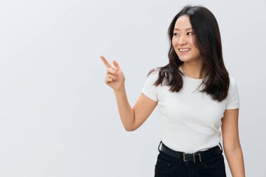 Beyaz tişörtlü, sevimli, neşeli Koreli genç bayan fotokopi çekmecesi dışında beyaz stüdyo arka planında yalnız poz veriyor. Reklam için en iyi teklif. İnsanlar Yaşam Tarzı Konsepti