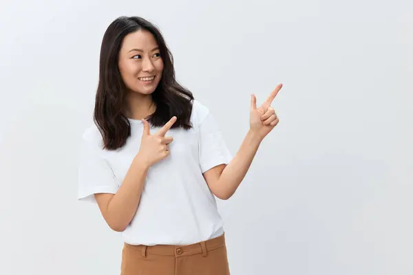 白い基本的なTシャツのポイントの指で美しく陽気な韓国の若い女性は 白いスタジオの背景の上に隔離されたコピースペースに脇に置きます Adのための最高のオファー 人々のライフスタイルコンセプト — ストック写真