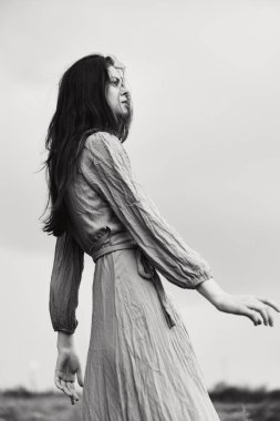 Elbiseli güzel bir kadın, el hareketleriyle hiç değişmemiş poz veriyor. Yüksek kalite fotoğraf