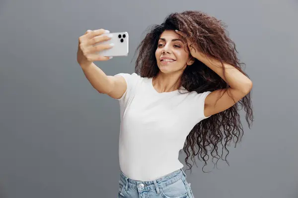 Tecnología Moderna Mujer Latina Rizada Sonriente Camiseta Blanca Posando Aislada —  Fotos de Stock