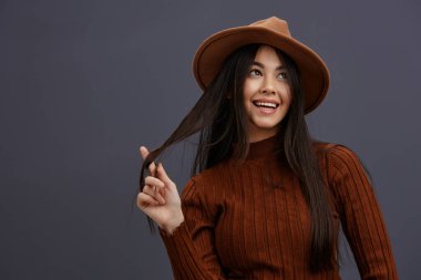 Kadın kahverengi şapkalı el, kahverengi süveterli süveter moda stüdyo modelini işaret ediyor. Yüksek kalite fotoğraf