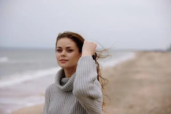 portrait of a woman cloudy weather by the sea travel fresh air Happy female relaxing. High quality photo