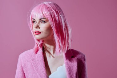 Pembe ceketli, pembe peruklu genç bir kadın arka planda renk değişikliğine uğramamış. Yüksek kalite fotoğraf