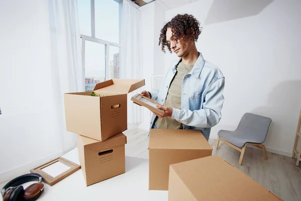 handsome guy unpacking things from boxes in the room Lifestyle. High quality photo