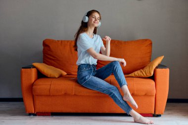 Turuncu koltukta müzik dinleyen bir kadın. Yüksek kalite fotoğraf