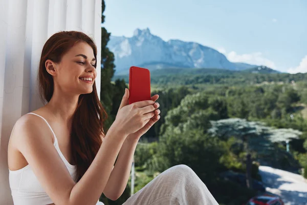 Portrait of gorgeous woman with a red phone Terrace outdoor luxury landscape leisure Relaxation concept. High quality photo