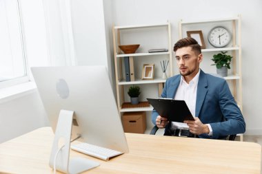 Takım elbiseli bir adam ofis yöneticisinin masasındaki evraklara yazıyor. Yüksek kalite fotoğraf