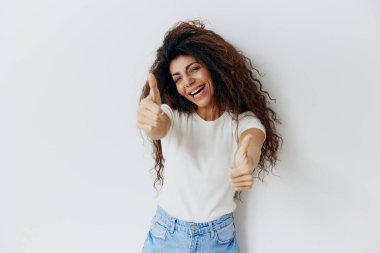 - Süper bir şey bu. - Evet. Aşırı neşeli kıvırcık kıvırcık Latin kadın kameraya bak, gülümse baş parmaklarını göster, harika fikir de. Moda markası için kopyalama alanı, bedava yer reklamı. Stüdyo çekimi izole edilmiş beyaz arkaplan