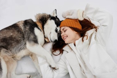 Karda neşeli bir kadın köpek arkadaşlığıyla oynuyor. Hayat tarzıyla. Yüksek kalite fotoğraf