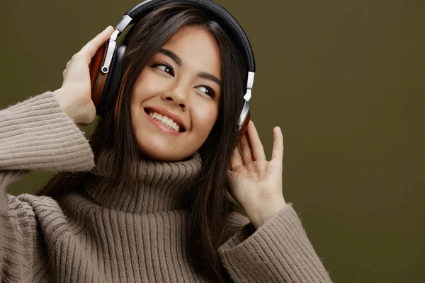 年轻女子无线耳机音乐有趣的技术绿色背景 高质量的照片 — 图库照片