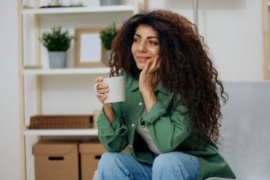 Mutlu şirin, bronzlaşmış, kıvırcık Latin bayandan hoşlanıyordu. Sevgiyle bakıyordu. Rahat gömlekli bir fincan çay kahvesi tutuyordu. Uzay Sancağını kopyala. Nostalji kavramı