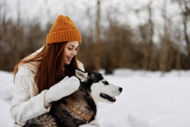 Genç kadın kış kıyafetleri karda köpeği gezdiriyor. Yaşam tarzı. Yüksek kalite fotoğraf