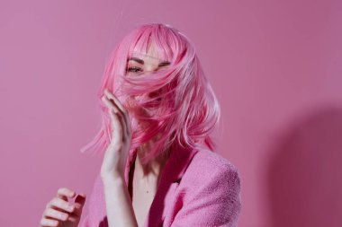 Pembe ceketli, pembe peruklu genç bir kadın arka planda renk değişikliğine uğramamış. Yüksek kalite fotoğraf