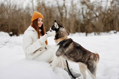 Neşeli kadın kış kıyafetleri karda köpeği gezdiriyor. Yaşam tarzı. Yüksek kalite fotoğraf