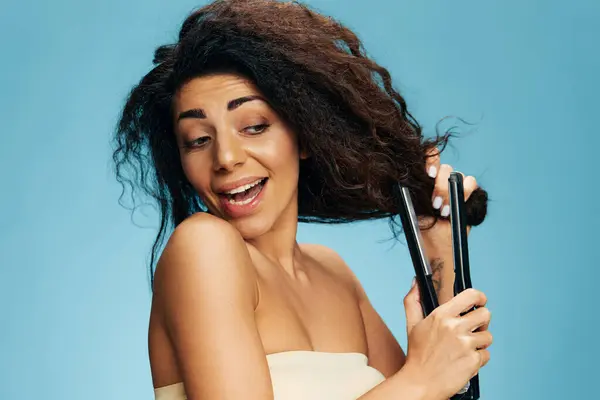 Güzel Gülümseyen Latin Kıvırcık Kadın Saç Düzleştirici Kullanıyor Yana Bakıyor — Stok fotoğraf