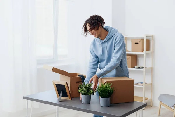 handsome guy unpacking with box in hand moving interior. High quality photo