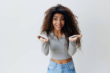 Bana gel. Heyecanlı Latin kadın kamerada ellerini uzatıyor, büyük görünmeyen bir nesneyi tutuyor, Arap kadın kucaklıyor ya da bir şey tutmak istiyor, beyaz arka planda tek başına duruyor, boşluğu kopyalıyor. 